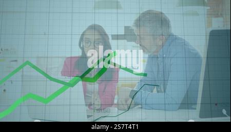 Analyzing financial data image over business colleagues discussing at desk Stock Photo