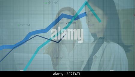 Businesswomen discussing data over financial graph image Stock Photo