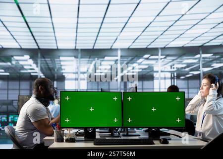 Engineer listening music, doing data center automation using machine learning on isolated screen computer. Woman wearing headphones integrating AI automation in server hub using chroma key PC Stock Photo