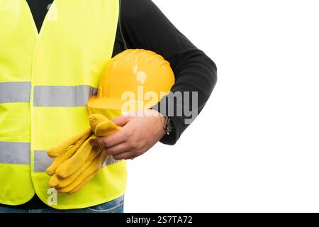 Close-up of male builder wearing fluorescent vest holding yellow safety protective hardhat and work gloves with blank copyspace isolated on white back Stock Photo