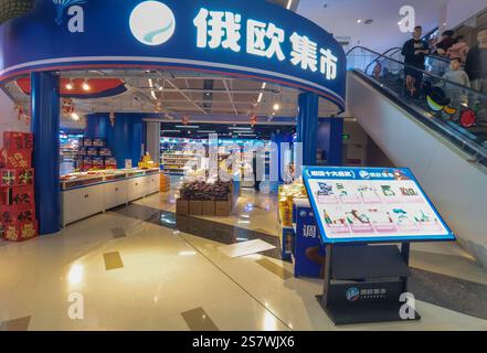 ShenZhen, China - January 20, 2025 : A vibrant Russian supermarket interior, showcasing colorful displays of goods and shoppers near an escalator.  Th Stock Photo