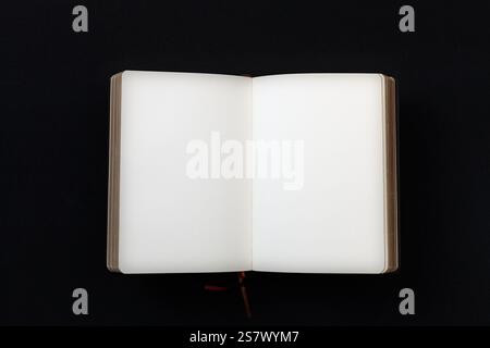 Open blank notebook with crisp white pages against a black background, symbolizing creativity and potential. Stock Photo