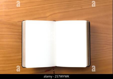 A notebook lies open on a wooden surface, featuring blank pages ready for writing or sketching. Stock Photo
