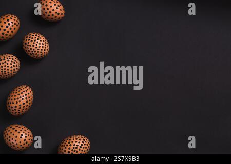Painted eggs with black dots. Top view of Easter eggs on black background. conceptual Easter flat lay with copy space, horizontal. Mockup for greeting Stock Photo