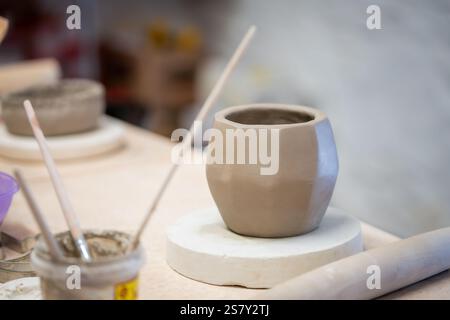 Making faceted vase. Handmade clay pottery  drying before being fire. Table in pottery studio. Ceramic workshop. The process of creating pottery. Stock Photo