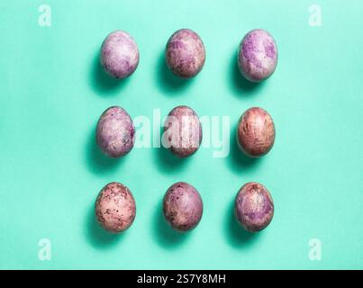 Colorful nine painted eggs for Easter on light green background. Easter flat lay with copy space. Easter eggs. Design for greetings and invitation car Stock Photo
