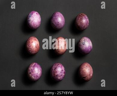 Colorful nine painted eggs for Easter on black surface. Easter flat lay with copy space. Easter eggs. Design for greetings and invitation cards Stock Photo