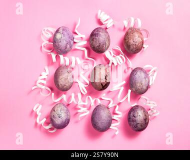 Easter eggs with white decorations on pink background. Easter layout. Greeting card design Stock Photo
