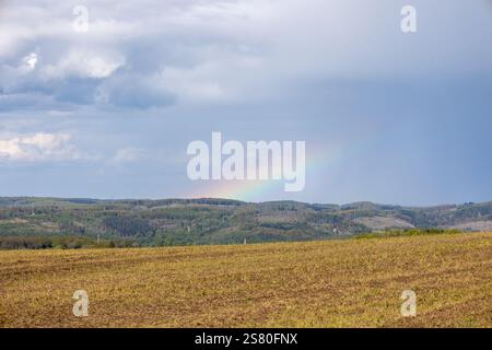 A rainbow is seen in the sky above a field Stock Photo
