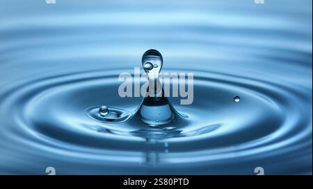 Clear water drop with small bubbles trapped in it, making ripples in blue Stock Photo