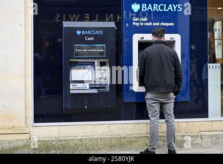 Man using a Barclays ATM cash machine, pay in cash and cheques, get cash, Cheltenham, UK Stock Photo
