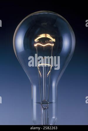 Incandescent light bulb showing glowing tungsten filament. Stock Photo