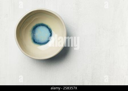 empty ceramic bowl on white painted table surface, top view Stock Photo