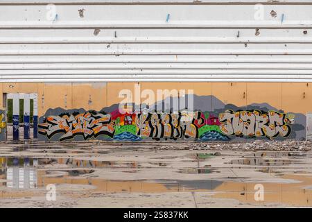 Abandoned and partially demolished industrial building with graffitis on wall and water on floor in Paimio, Finland Stock Photo