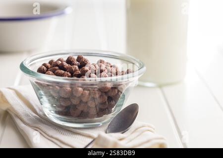 Breakfast cereal chocolate balls in bowl on a white table. Stock Photo