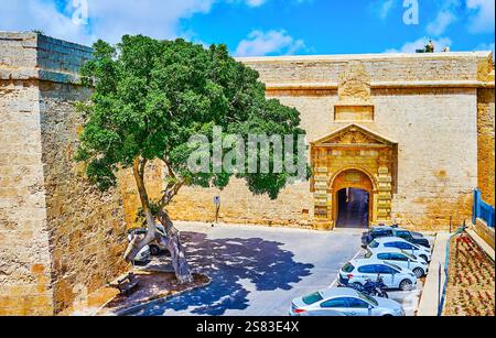 The outer wall of Mdina fortress with a view on historical Greek Gate, decorated with carved decorations in Mdina, Malta Stock Photo