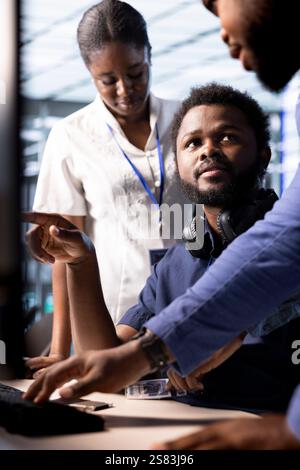 Data center coworkers doing brainstorming, using programming languages to construct algorithms and build applications. Teamworking server hub colleagues collaborating on debugging and optimizing code Stock Photo