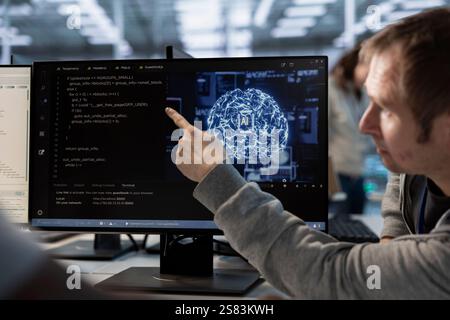 Manager overseeing programmers using artificial intelligence technology to optimize data center. Supervisor checking progress done by worker in server hub using AI tech to streamline operations Stock Photo