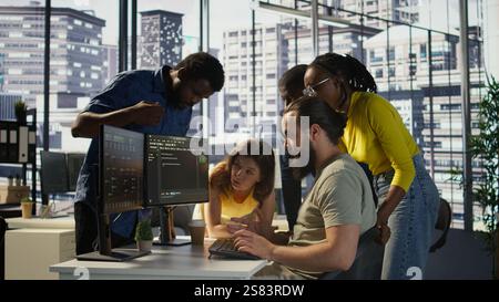 Programmers gathered together to conduct code review to fix errors, identifying technical issues with company software. Team of developers doing brainstorming, optimizing code, camera B Stock Photo