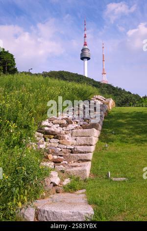 Ruined sections of the city wall, going up a grassy hill. At the Seoul City, Wall, Hanyang Doseong Historic Site Museum in Seoul, South Korea. Stock Photo