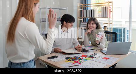 Creative UX UI team collaborating on design project in a modern office, showcasing diverse professionals Stock Photo