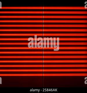 Sunbeams through a roller shutter on a shiny red surface. Stock Photo