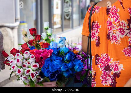 Artifical flowers to be sold on Selwyn Selwyn-Clake market in Victoria, Seychelles with back of a woman wearing flowered blouse Stock Photo