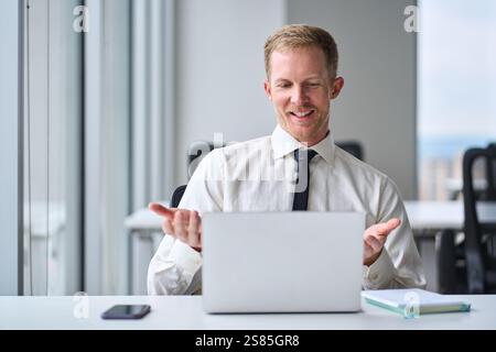 Busy happy young businessman having virtual meeting on laptop working in office. Stock Photo