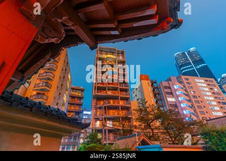 View of Tokyo Tower reflecting in city buildings and Rurikoji Buddhist Temple at night, Minato City, Tokyo, Honshu, Japan Stock Photo