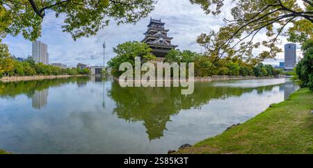 View of Hiroshima Castle, with museum, reflecting in Moat, Motomachi, Naka Ward, Hiroshima, Honshu, Japan Stock Photo