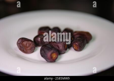 Serving date fruits, islamic holy month ramadan concept image idea caucasian woman hands holding serving date fruits. Special nutrition snack for Iftar.  Stock Photo