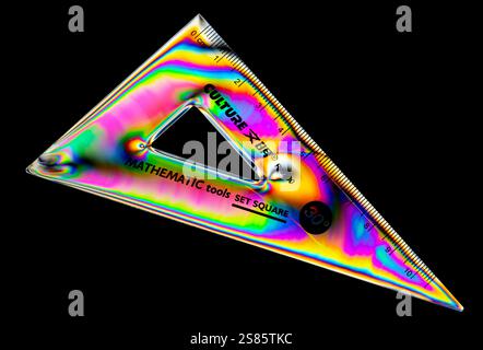A plastic triangle from a Geometry set, photographed using cross-polarised light, showing a range of colours Stock Photo
