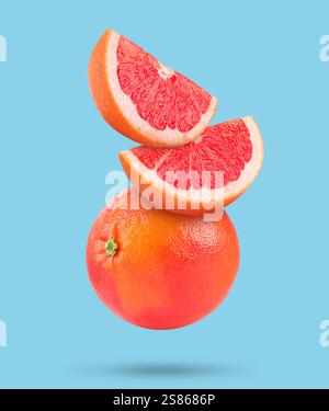 Fresh grapefruits in air on light blue background Stock Photo