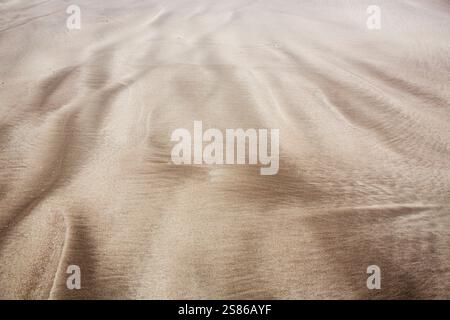 Patterns made in the sand on a beach by the action adn flow of the sea and waves over the sand. Stock Photo