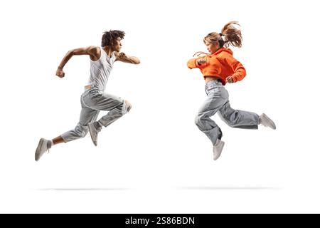 Full length profile shot of an african american male dancer and asian female jumping isolated on white background Stock Photo