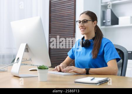 Programmer working on computer at wooden desk indoors Stock Photo