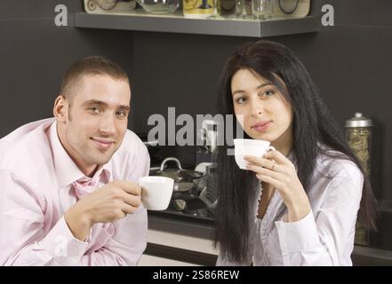 Young adult couple having their coffee in the kitchen, Moscow, Russian Federation Stock Photo