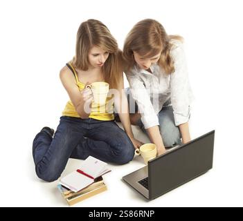 Two young pretty blond women working with laptop computer, Russian Federation Stock Photo