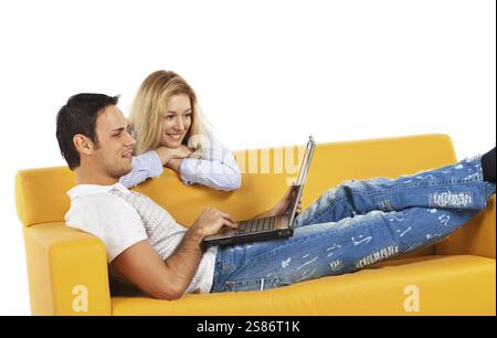 Happy young man and woman sitting together and looking at computer screen, Russian Federation Stock Photo