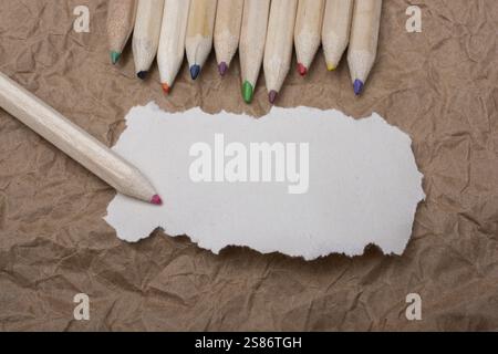 Color wooden pencils and torn note paper for text or message Stock Photo