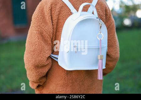 Woman with pink leather keychain on her backpack outdoors, closeup Stock Photo