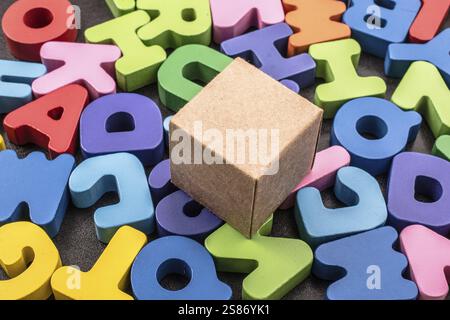 Cardboard box cube and Colorful Letters of Alphabet Stock Photo