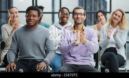 Happy multiethnic employees having fun while discussing project, sharing ideas, informal brainstorming sitting on chairs Stock Photo