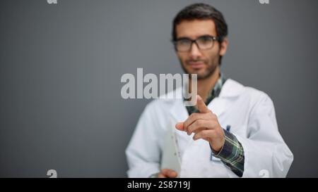 Caucasian doctor man holding a folder cheerful smiles pointing to front. Stock Photo