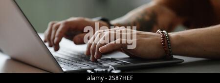 Website header shot male hands typing on keyboard of laptop writing code in office, copy space Stock Photo