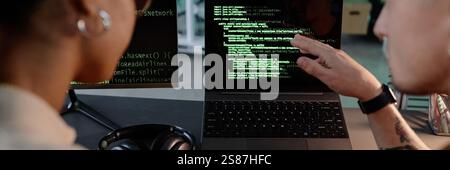 Website header shot of unrecognizable male and female colleagues pointing at laptop screen discussing code debugging while working collaboratively in office Stock Photo