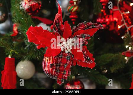 This image features a detailed closeup view of a beautifully adorned Christmas tree decorated with vibrant red decorations and ornaments Stock Photo