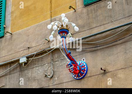 A decorative street lamp representing the Contrada of the snail ,Contrada Chiocciola on a street wall in Siena ,Italy Stock Photo