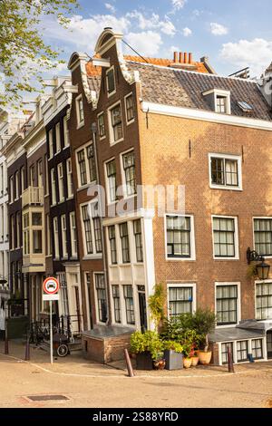 Medieval crooked and narrow canal house on the corner in the center of Amsterdam. Stock Photo