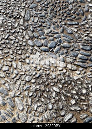 Pebbles granite stone block paving background. Paving work on a sidewalk, yard, home. paving stone floor laying brick by landscape gardener. Stock Photo